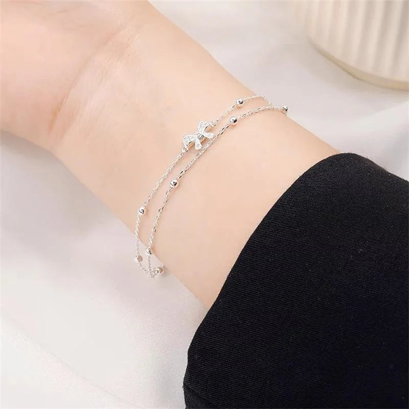 Zartes koreanisches zweilagiges Armband für Damen und Mädchen mit süßer Schleife, Stern und Mond, funkelnden Zirkonia und verstellbarer Kette.