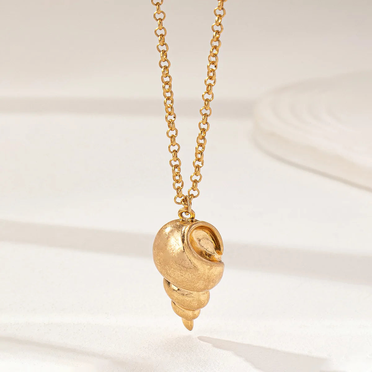 Collier pendentif conque dorée simple et tendance pour femme