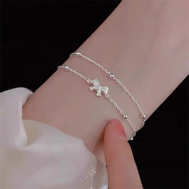Zartes koreanisches zweilagiges Armband für Damen und Mädchen mit süßer Schleife, Stern und Mond, funkelnden Zirkonia und verstellbarer Kette.