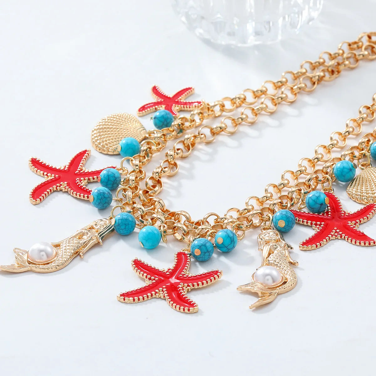 Collier ras-de-cou en alliage mixte avec pompon et perles, orné d'étoiles de mer et de conques, idéal pour l'été.