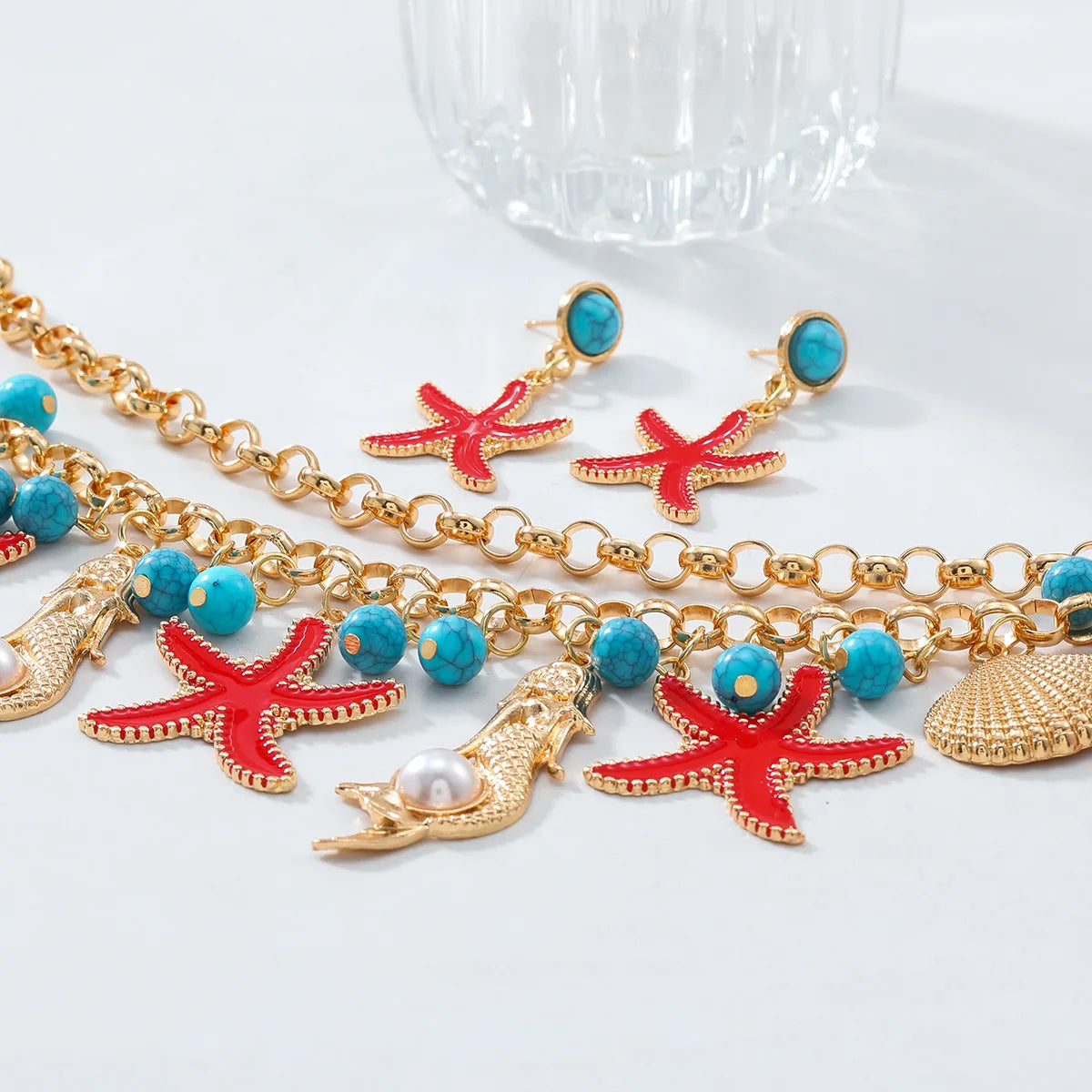 Collier ras-de-cou en alliage mixte avec pompon et perles, orné d'étoiles de mer et de conques, idéal pour l'été.